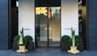 a glass door with plants in front of a building