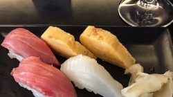 a plate of sushi and a glass of wine