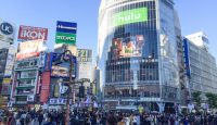 a crowd of people walking in a busy city