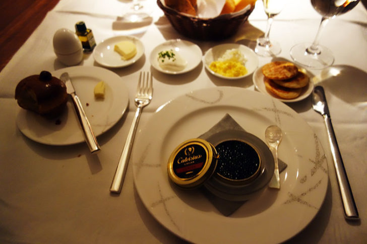 a table with plates of food and a bowl of butter