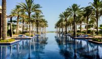 a pool with lounge chairs and palm trees