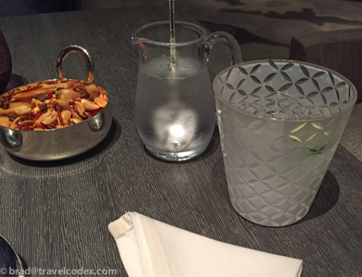 a bowl of food and a glass of water on a table