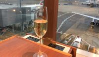 a glass of champagne in front of an airport