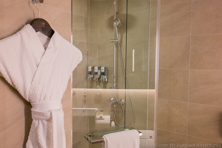 a shower with a bathrobe and a shower head