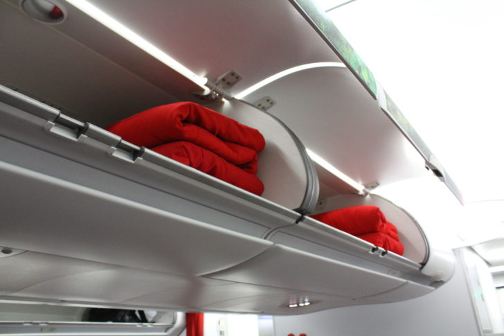 a shelf with red blankets on it