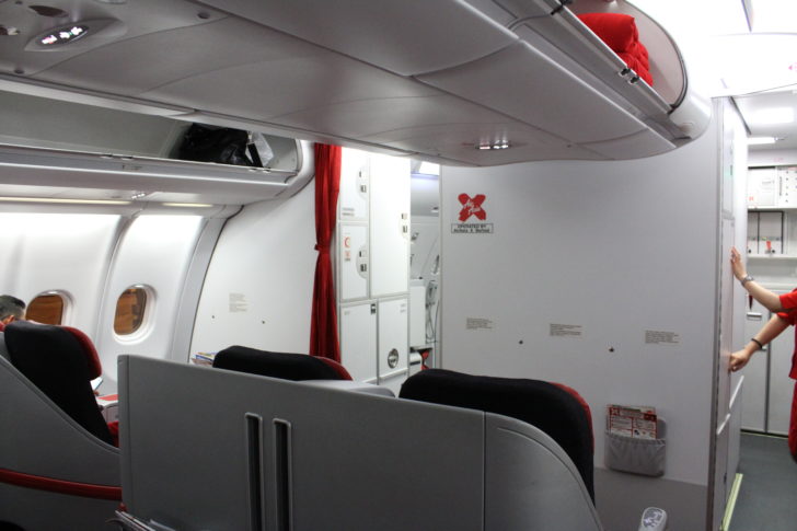 a plane with a shelf and a red curtain