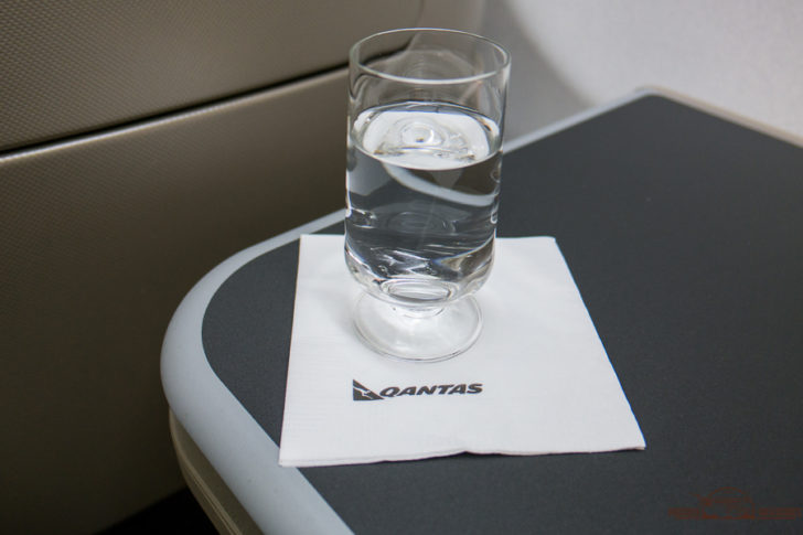 a glass of water on a napkin on a table