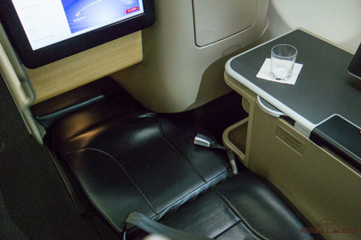a seat with a glass on the side of it