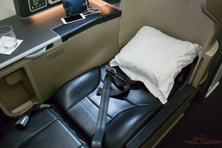 a seat with a seat belt and a pillow on the seat