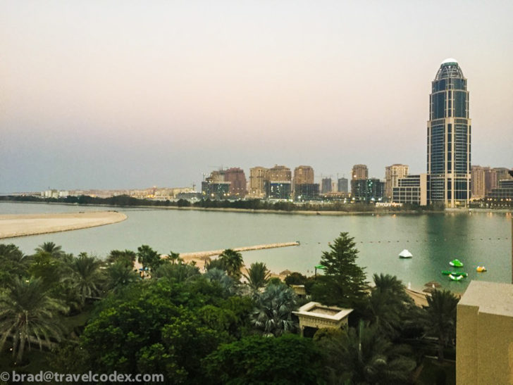 a city skyline with a body of water and trees