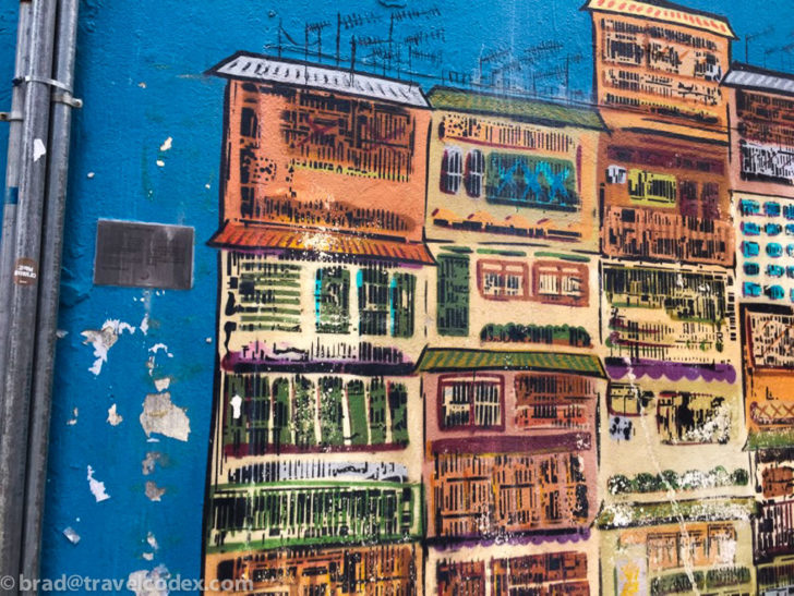 a wall with a painting of buildings