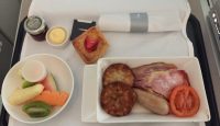 a plate of food and a bowl of fruit on a table