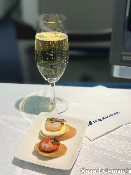 a glass of champagne next to food
