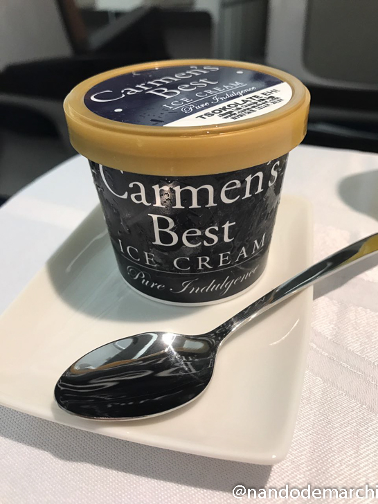a container of ice cream on a plate with a spoon