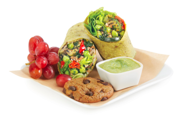 a plate of food with a bowl of dip and a cookie
