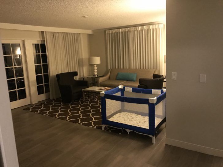 a living room with a baby crib and a couch
