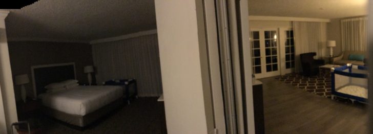 a white wall with a bed in the background