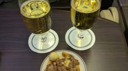 a plate of food and a couple glasses of beer