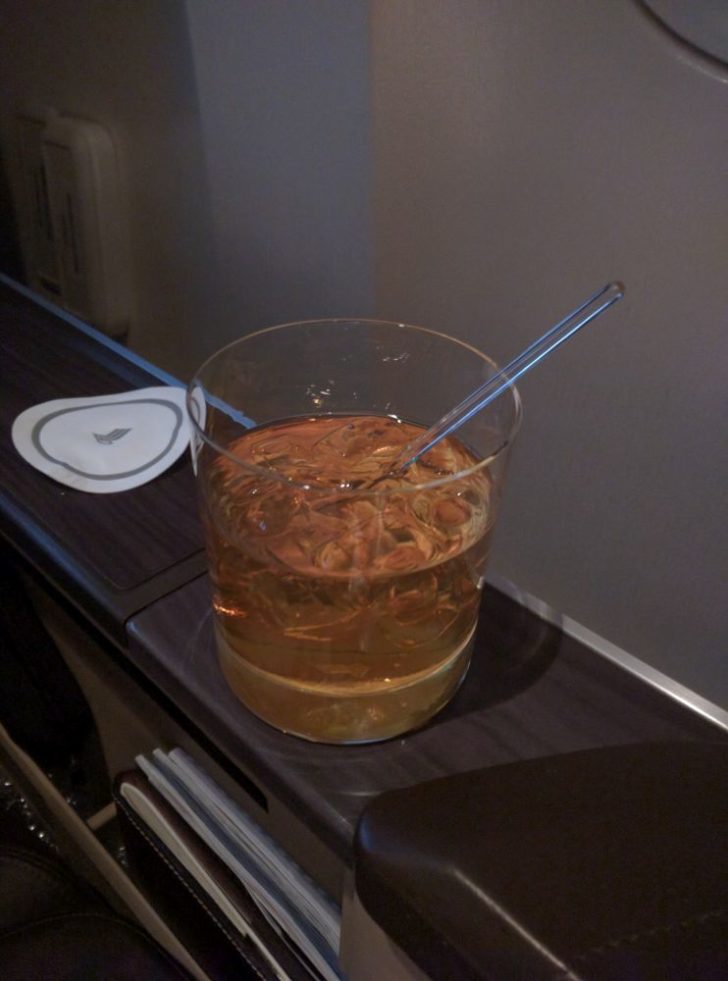 a glass with liquid and a spoon on a table