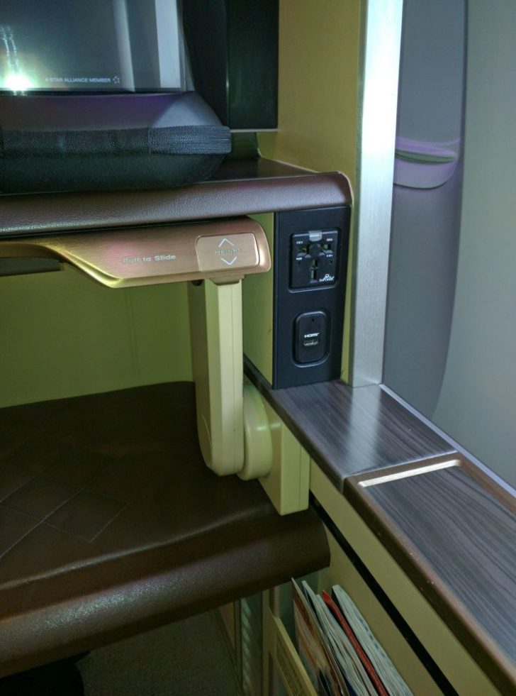 a table with a power outlet and a black bag on top