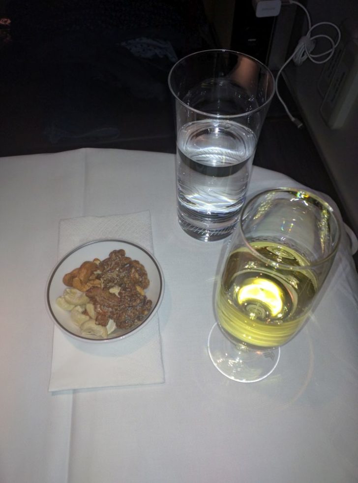 a bowl of cereal and a glass of water on a table