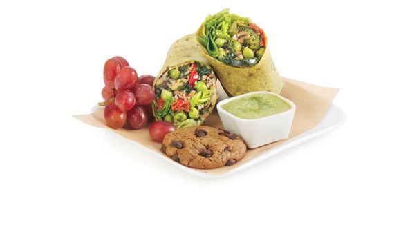 a plate of food with a bowl of dip and a cookie