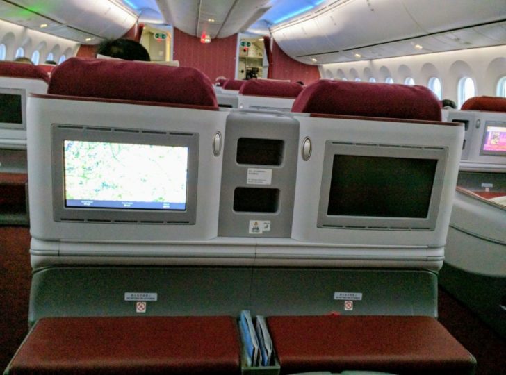 a row of seats with monitors on the side