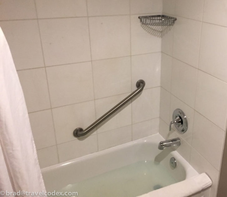 a bathtub with a metal bar in a bathroom