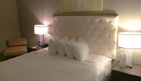a bed with white pillows and a white headboard