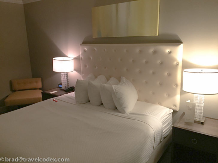 a bed with white pillows and a white headboard