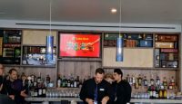 a group of people standing at a bar