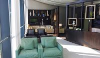 a room with green couches and a black shelf