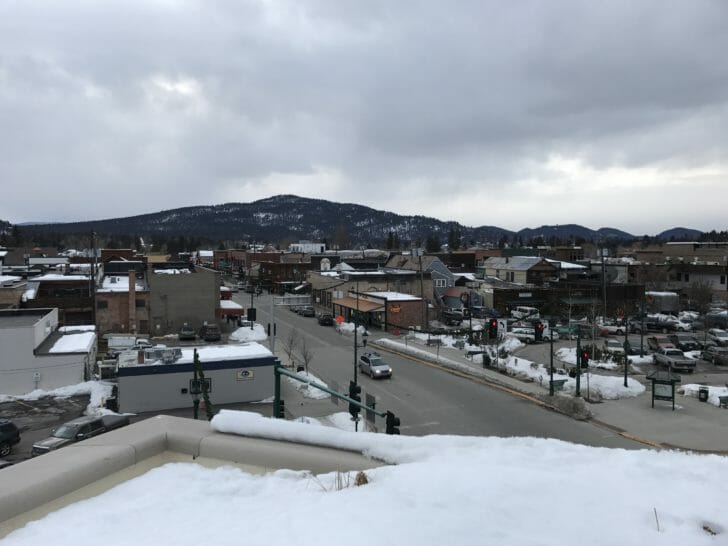 a snowy city with mountains in the background