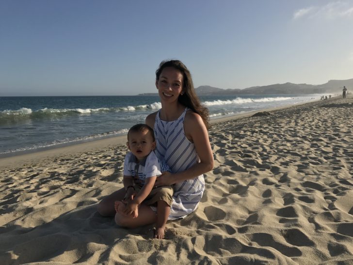 a woman and baby on a beach