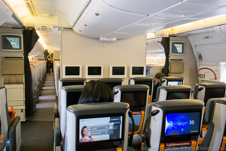 a person sitting in an airplane with a television set