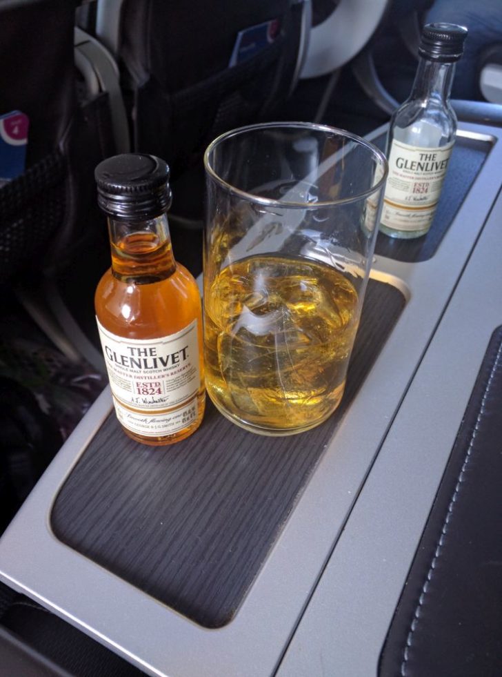 a bottle and glass of alcohol on a tray