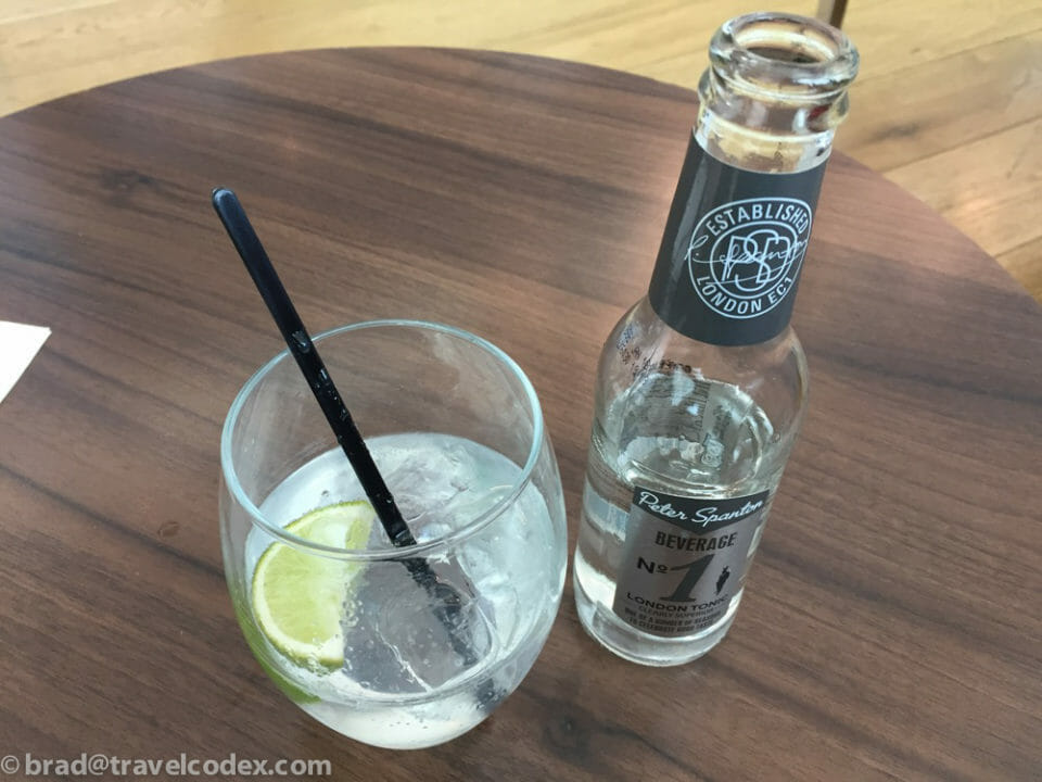 a glass of liquid and a bottle of alcohol on a table