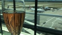 a glass of champagne in front of an airport