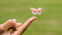 a person's hand holding a small drone