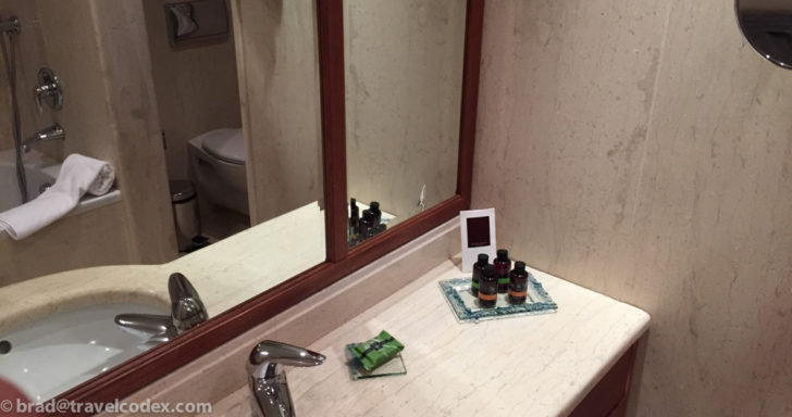 a bathroom sink with a mirror and a small tray of toiletries