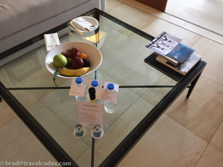 a bowl of fruit on a glass table