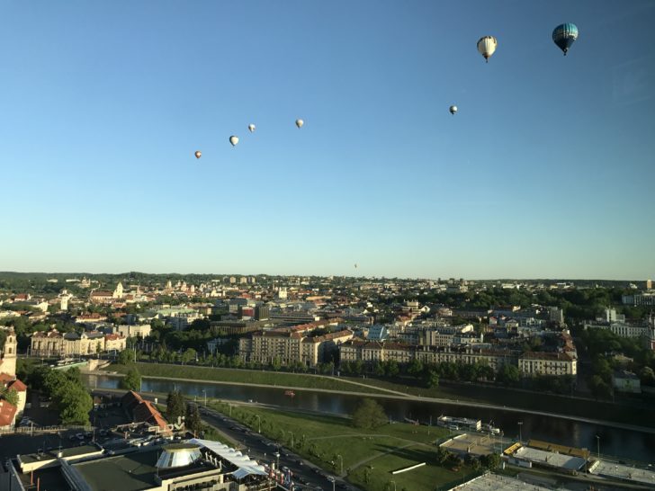 a group of hot air balloons in the sky over a city