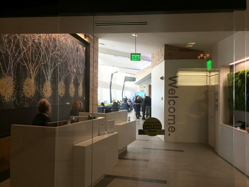 a lobby with a glass wall and people in the background