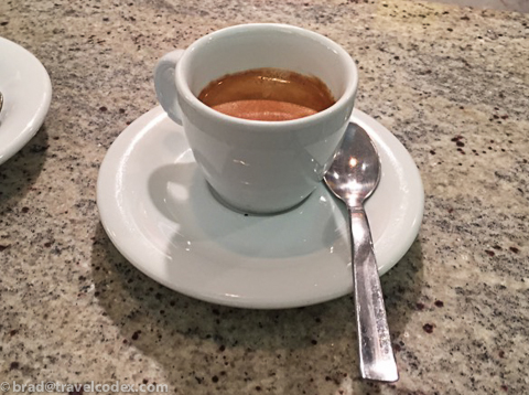a cup of coffee on a saucer with a spoon