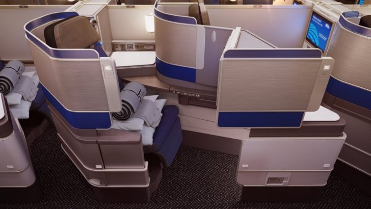 an airplane cabin with a chair and a blanket