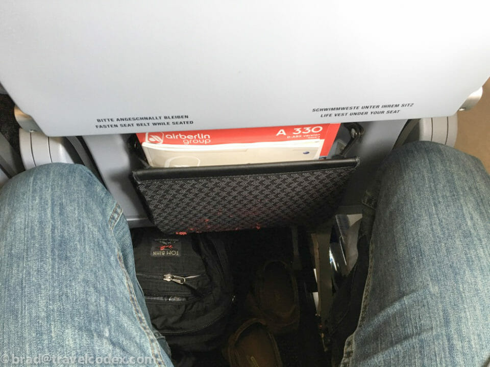 a person's legs in jeans and a black bag