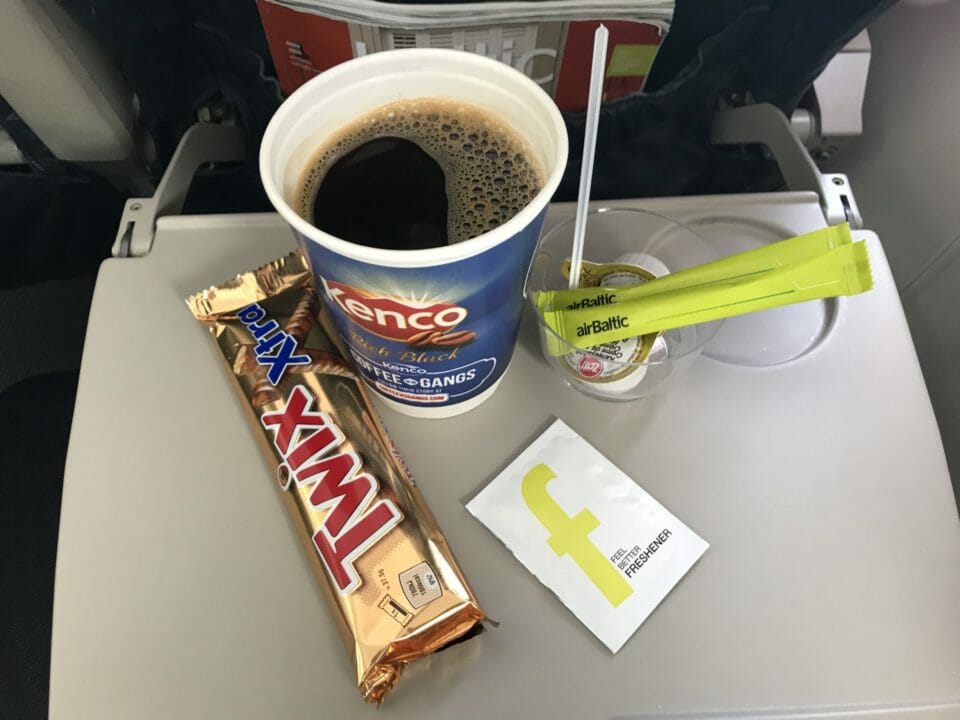 a cup of coffee and candy bar on a tray
