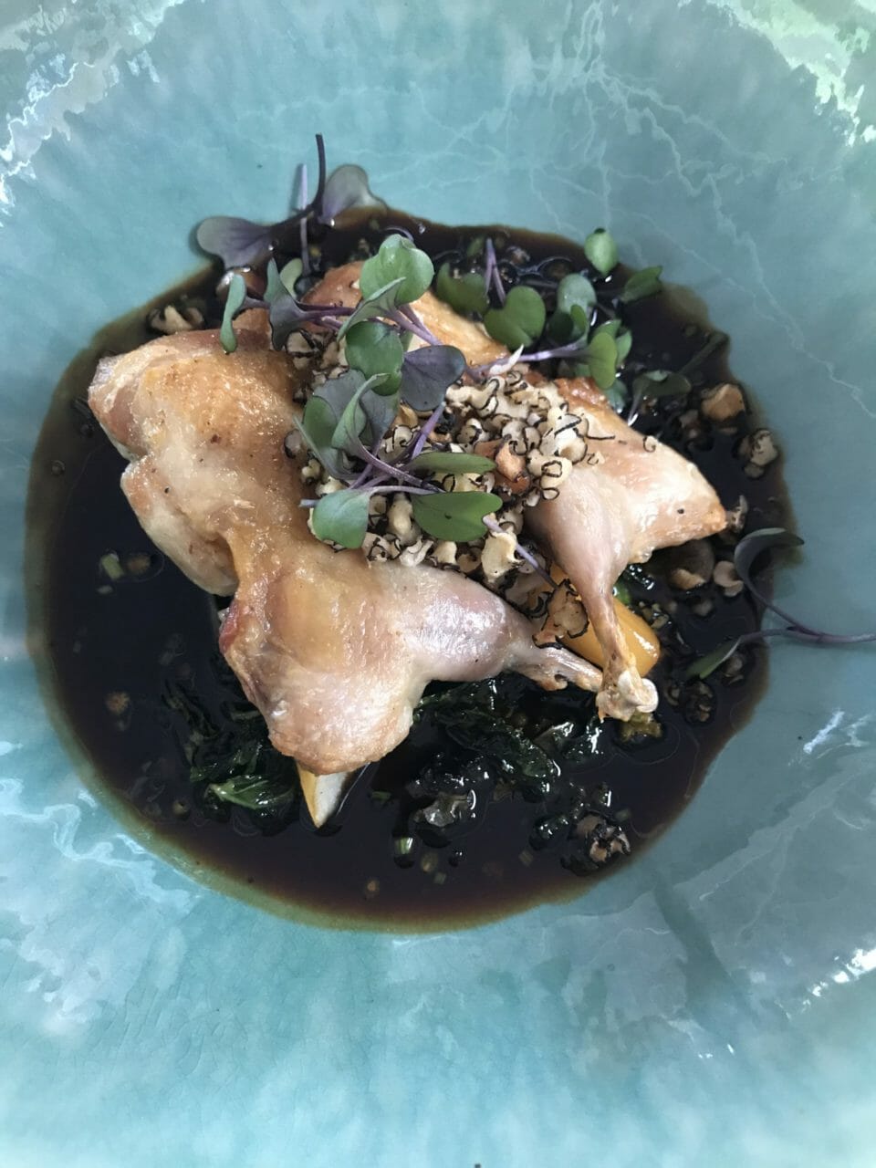 a bowl of food with greens and meat