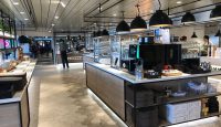 a restaurant with a counter and people walking around