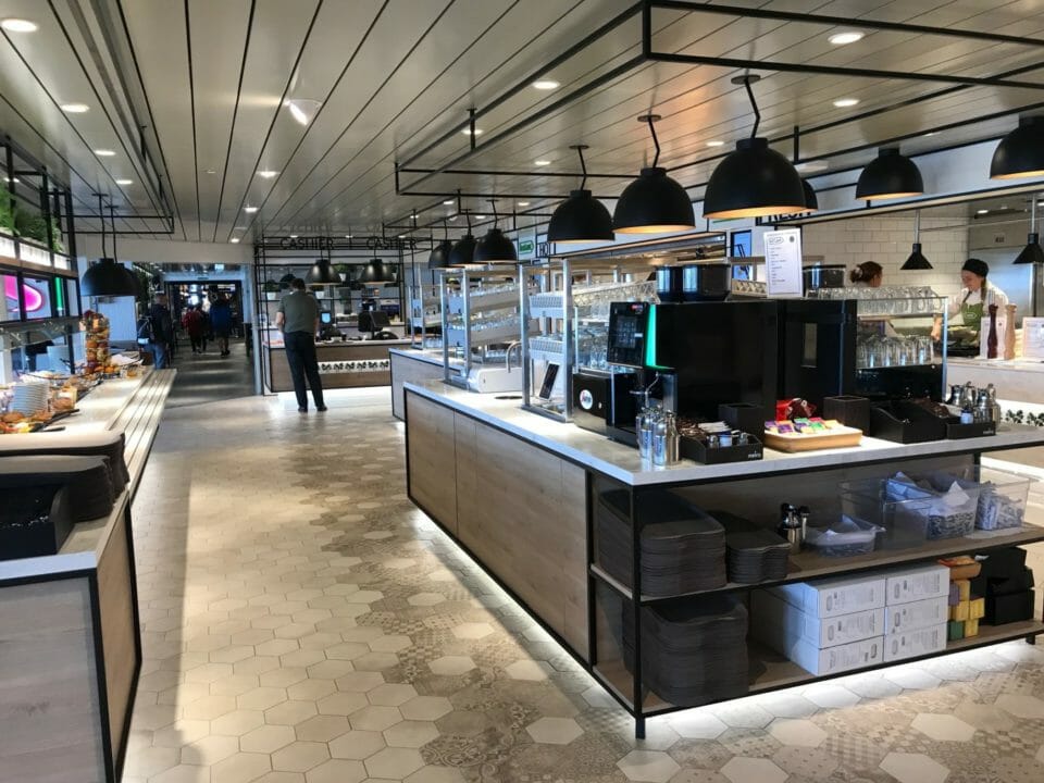 a restaurant with a counter and people walking around